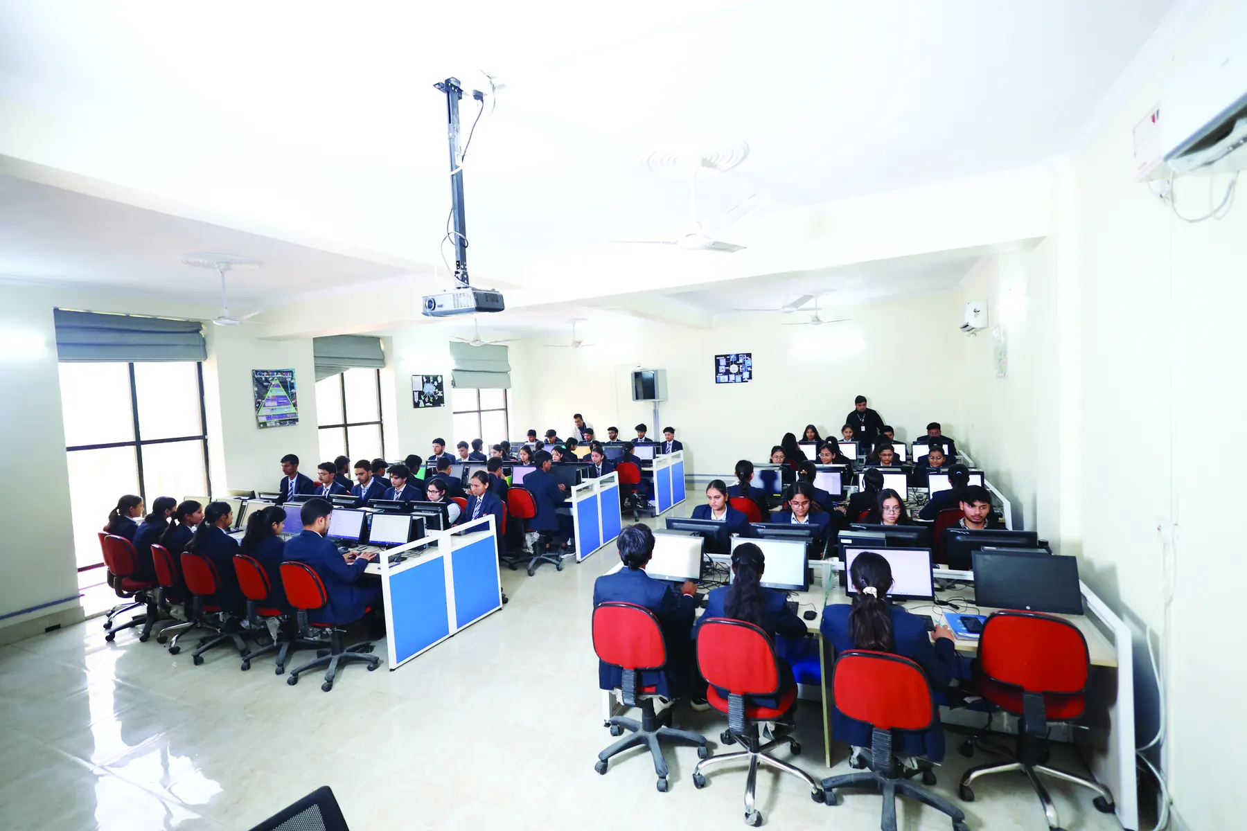 A full computer lab with students at rows of workstations