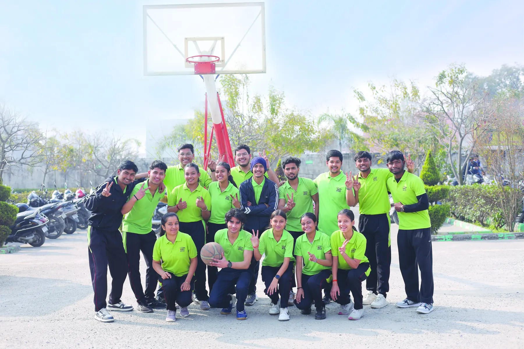 The HEC sports team in green jerseys on the basketball court