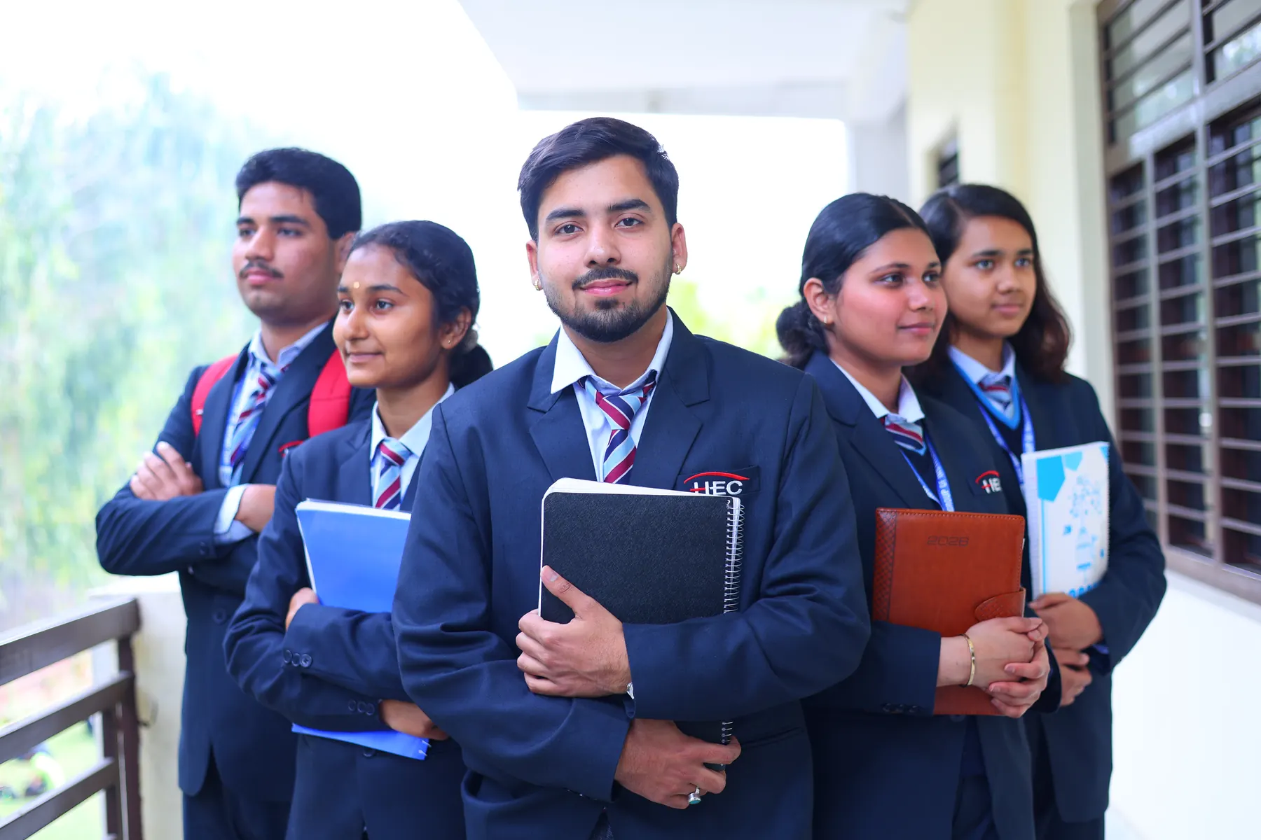 A group of students in HEC blazers holding notebooks